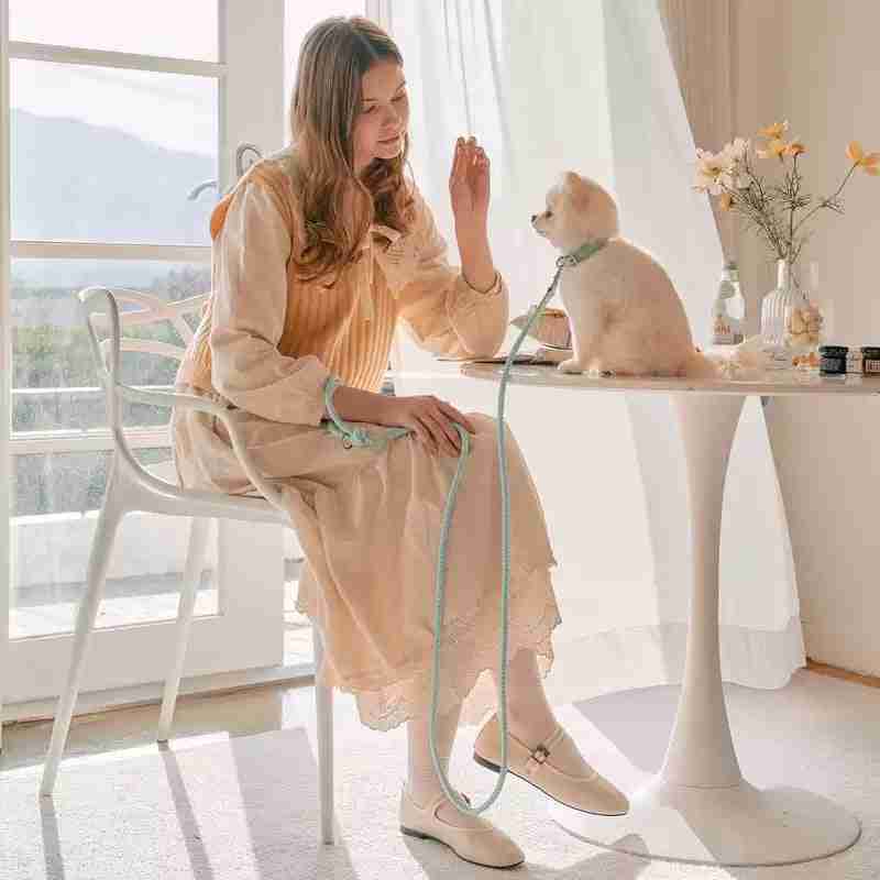 Woman with dog on leash sitting at table