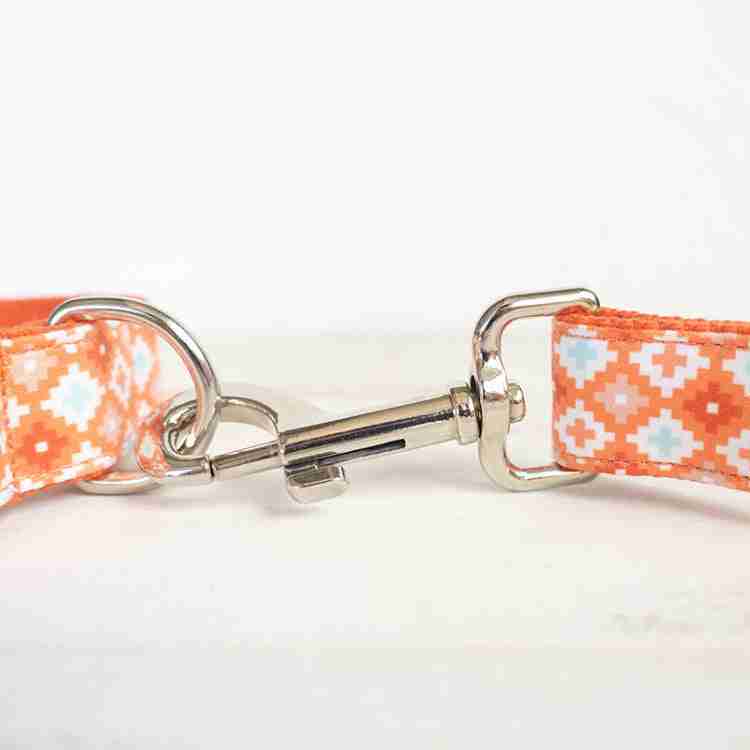 Close-up of adjustable metal clip on orange patterned dog leash