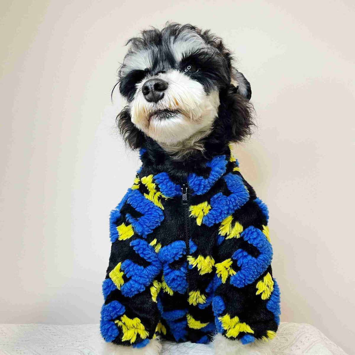 Pet fleece jacket with blue, yellow, and black pom-poms