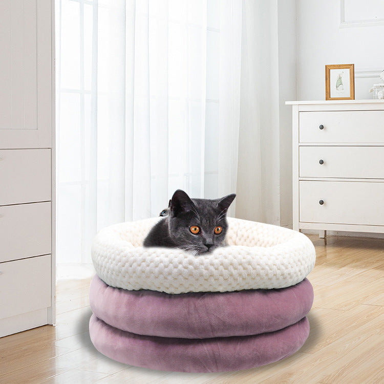 Pet bed with round velvet cushion and cat resting