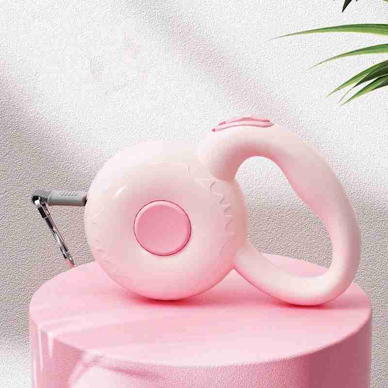 Pink retractable dog leash with reflective rope on pink pedestal