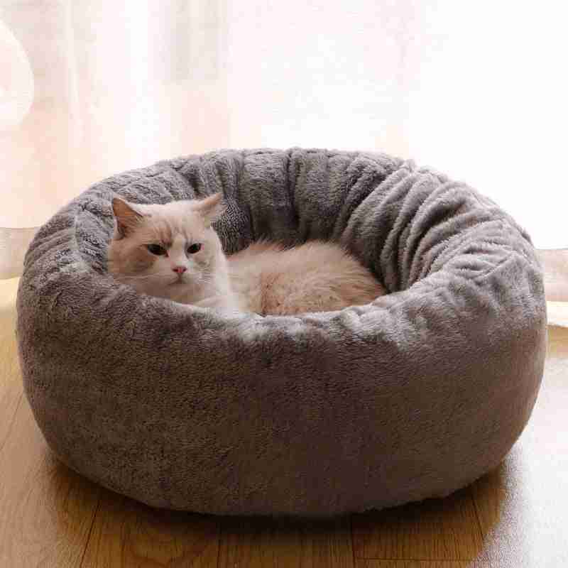 Light gray plush pet bed with cat lying inside